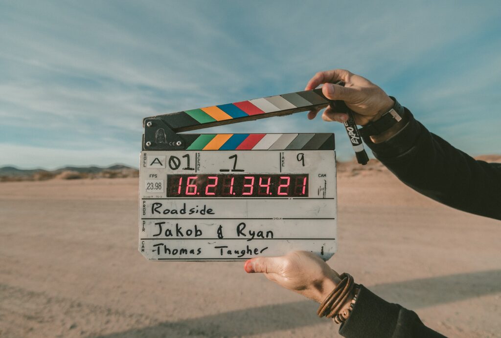 Klaps filmowy na tle piaszczystego podłoża.